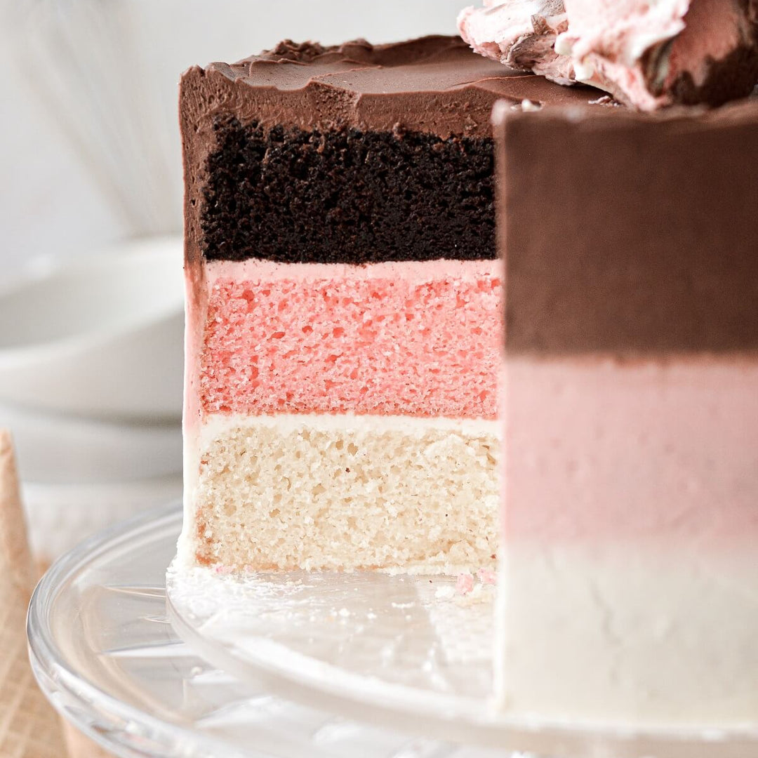 Neapolitan cake on a glass cake platter