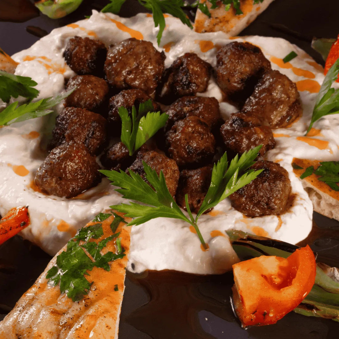 tender grilled beef and lamb koftas nestled on a smoky, velvety eggplant purée