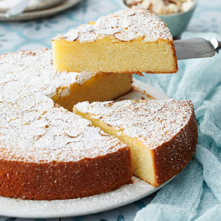 Sliced cake with powdered sugar on a plate with a light blue background