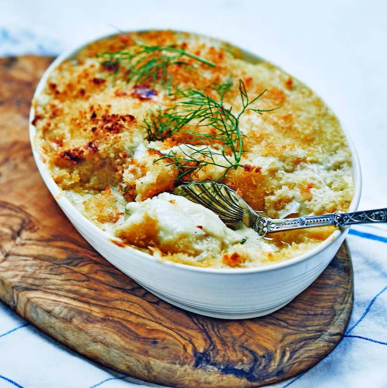 cod au gratin on a wood board