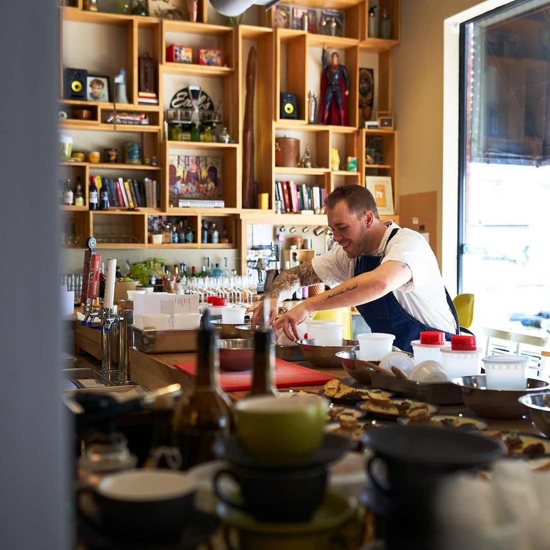 an urban element chef excitedly prepares the kitchen counter before guests join the culinary event.