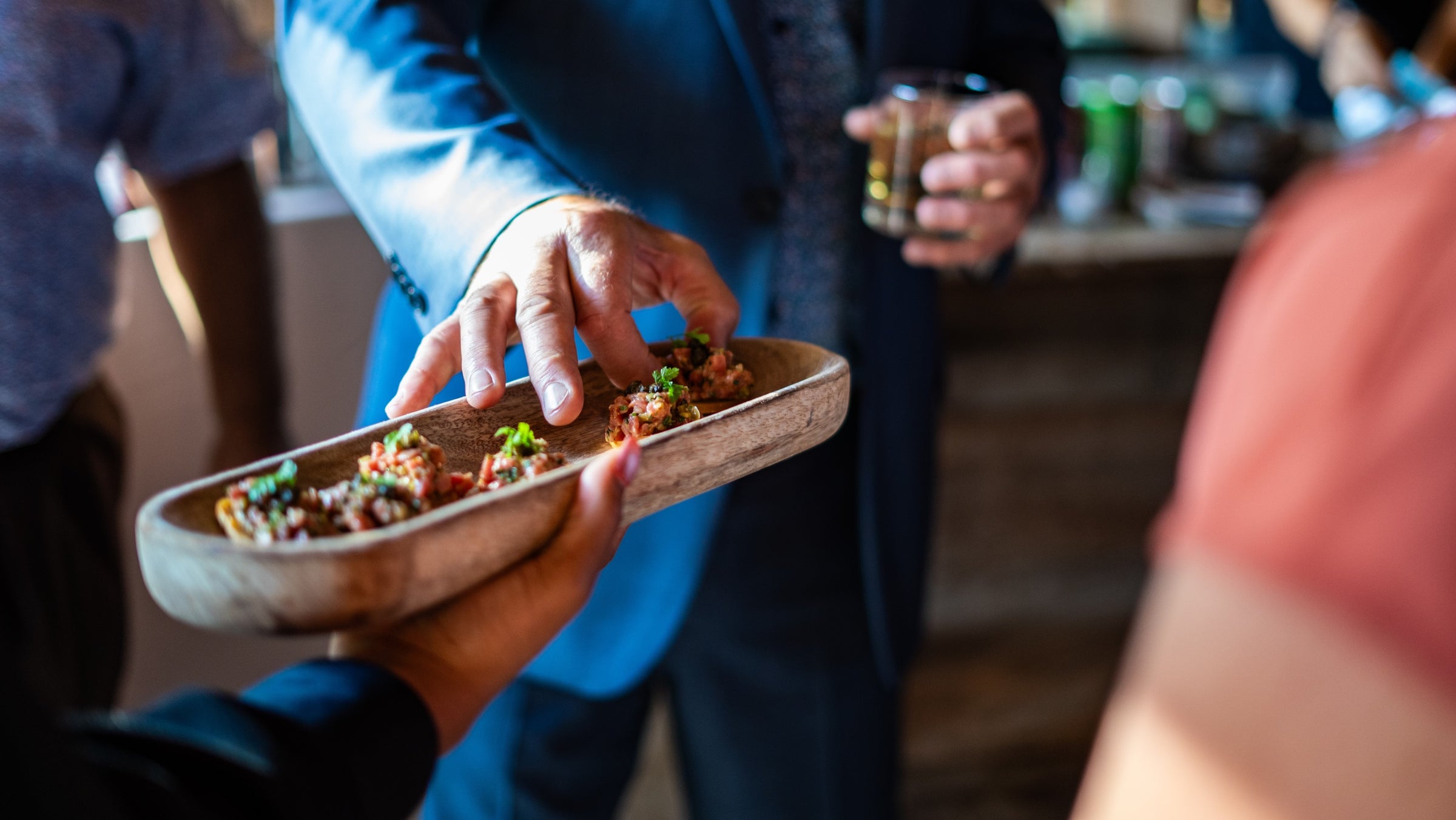 a hand reaches for an urban element catering passed canape