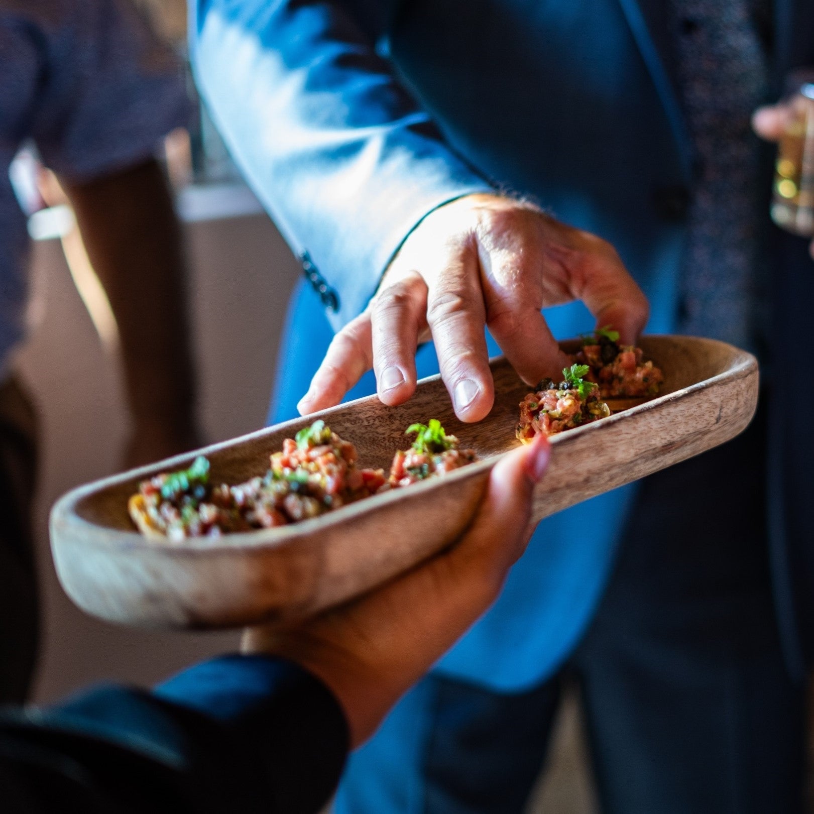 a hand reaches for an urban element catering passed canape